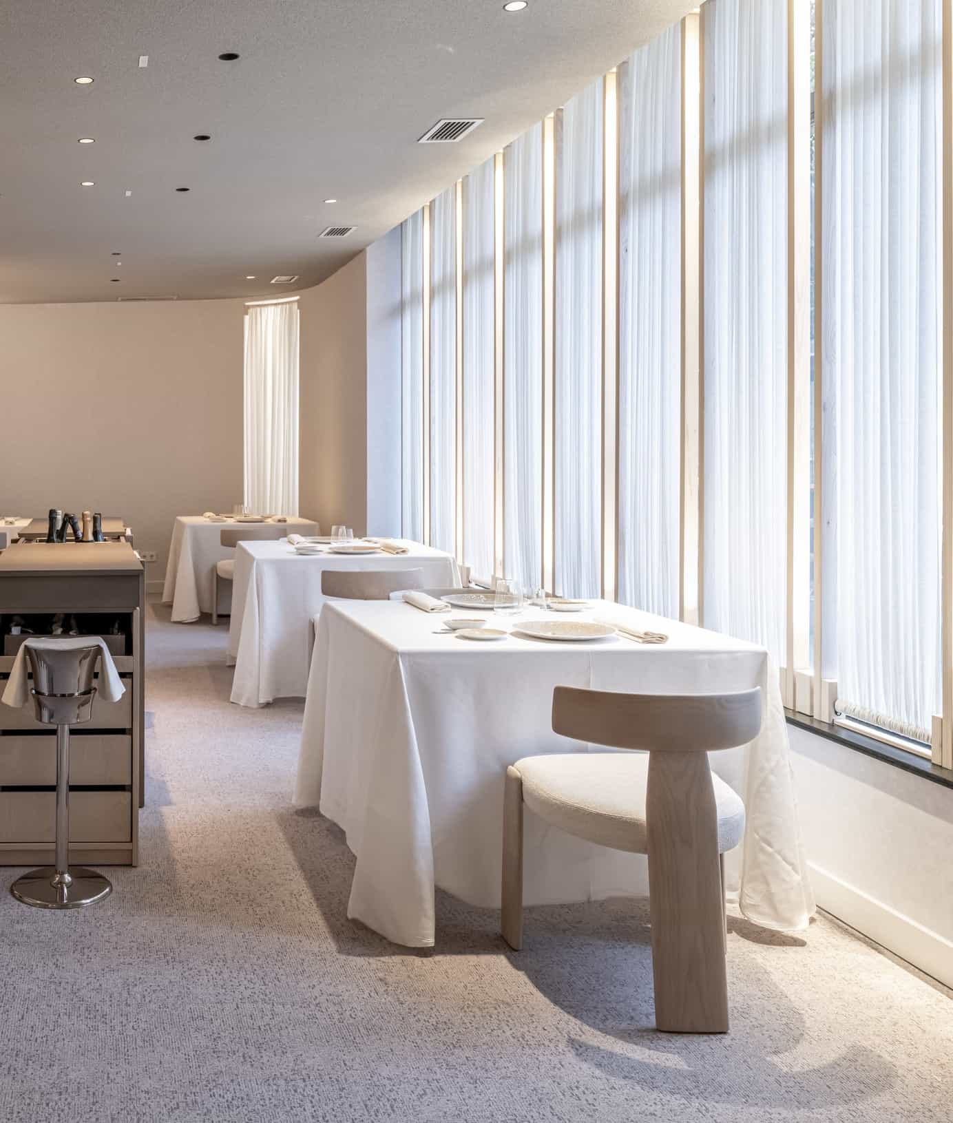 Sillería de alta restauración de Andreu World y mesas vestidas alineadas junto a los grandes ventanales del Restaurante Clos.